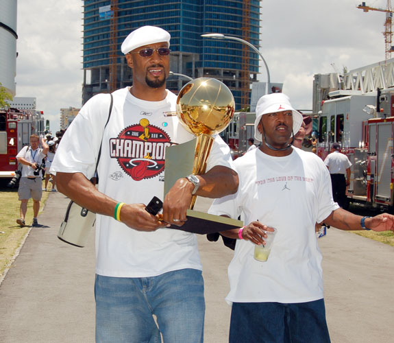 Miami Heat center Alonzo Mourning walks with the Larry O'Brien Trophy in tow toward the team's NBA Championship Parade.