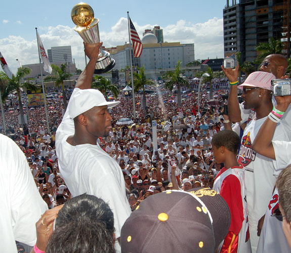 Miami Heat guard Dwyane Wade hoists the NBA Finals MVP Trophy in front of fans during the team's NBA Championship celebration at the Arena.