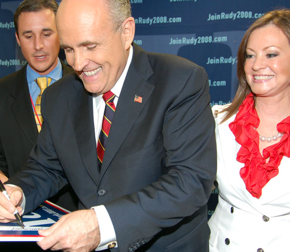 Former New York Mayor Rudolph Giuliani signing autographs for supporters at a rally after debating fellow Republicans on campus at the University of Miami.